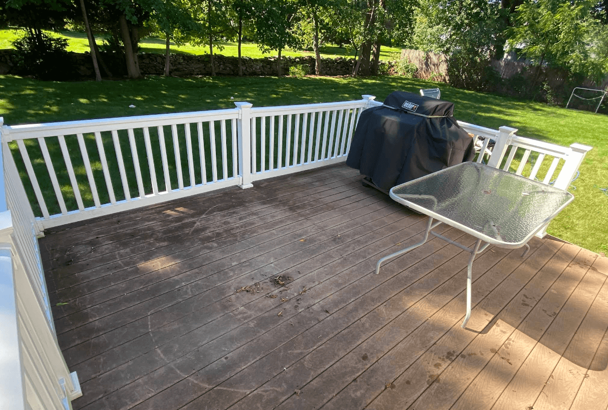 Dark weathered wooden deck with visible dirt, mold stains, and debris before professional pressure washing service in Rhode Island